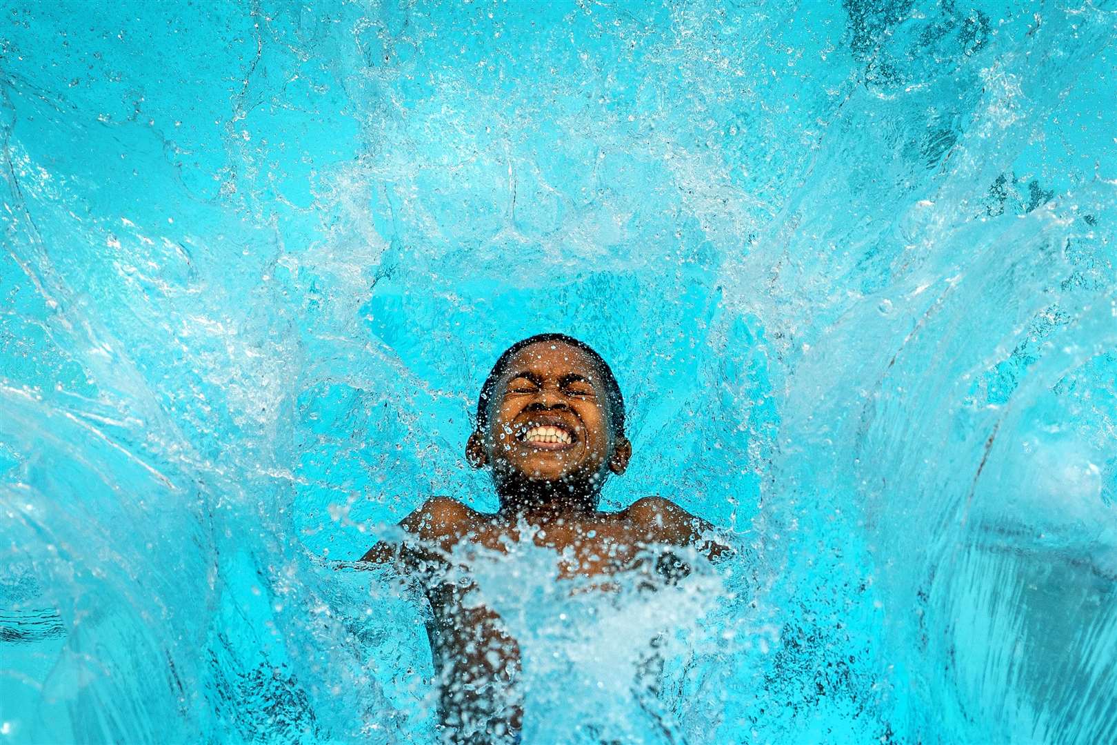 Reuben Hurst, 13, jumps into Charlton Lido in south London (Victoria Jones/PA)