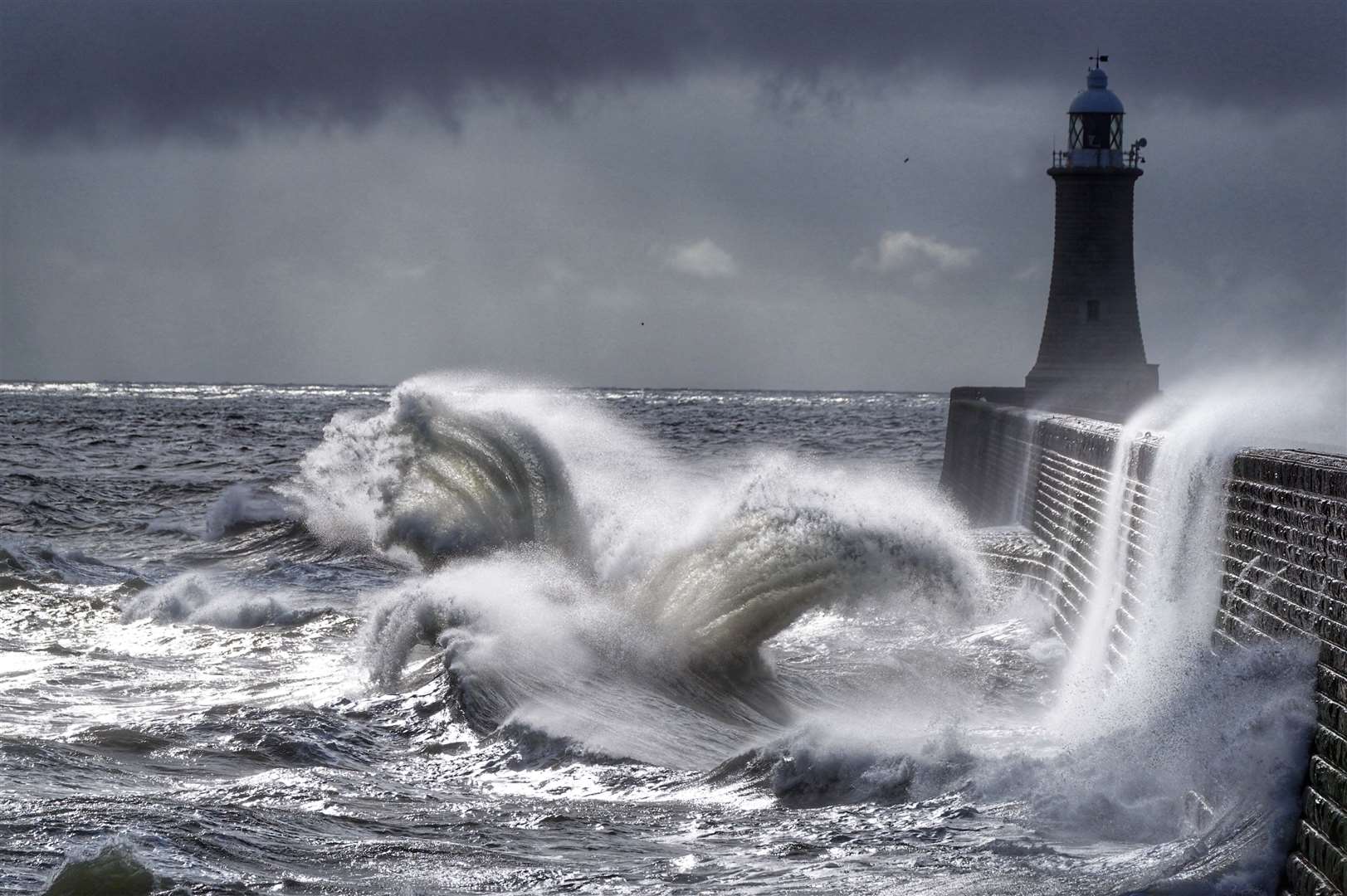 But it was a different story in July, when wet and wild conditions brought stormy seas, with huge waves crashing over the pier at Tynemouth (Owen Humphreys/PA)