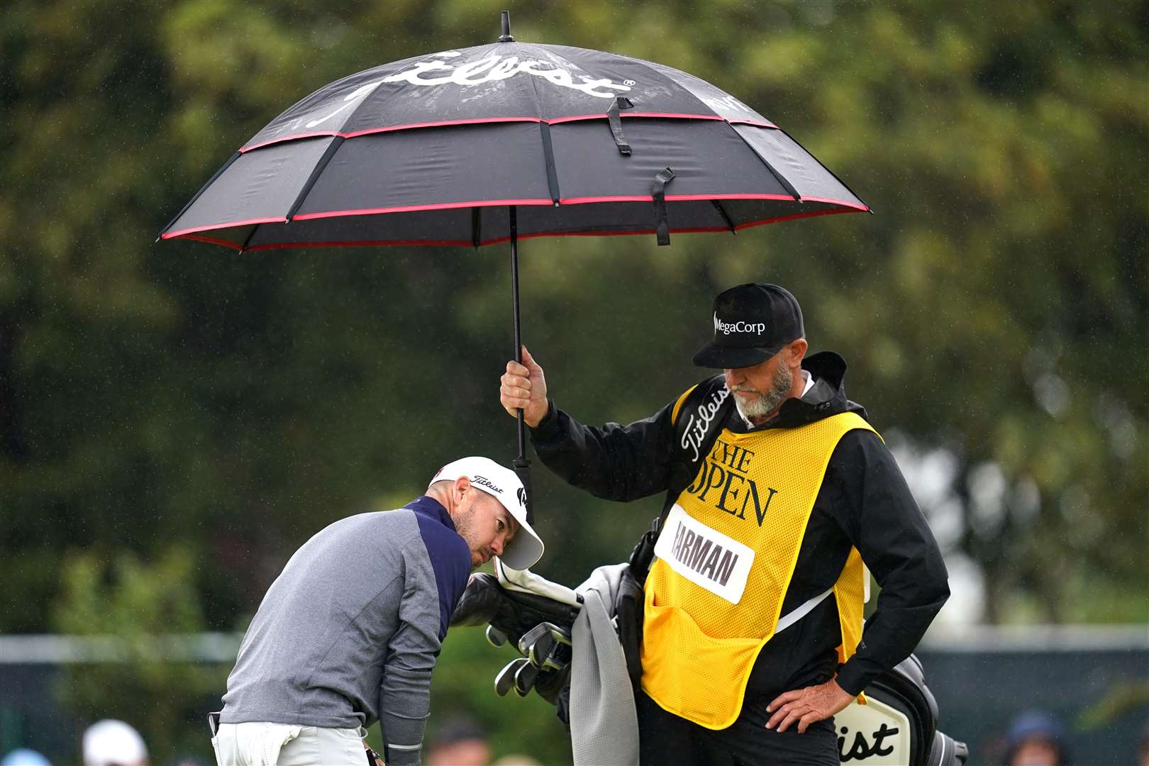 The US’s Brian Harman (left) is shielded from the weather during day three of The Open at Royal Liverpool (David Davies/PA)