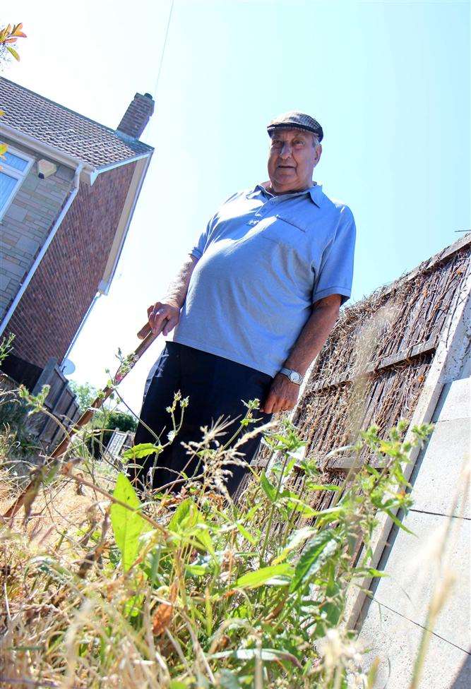 Maurice Goble in the alleyway next to his house which is completely overgrown