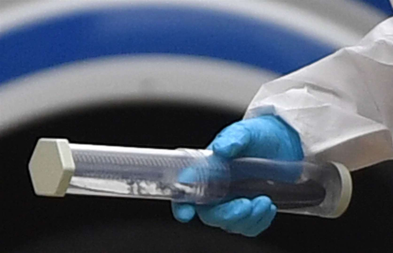 A police forensics officer holding a sealed container with a black handled knife inside (Jacob King/PA)