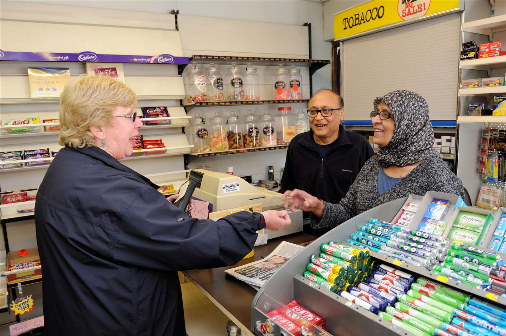 Ashraf and Shamim, serving loyal customer Rosemary Cockerill.