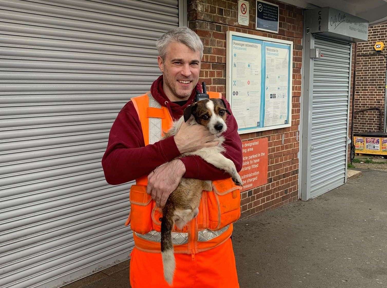 A member of the Network Rail team with the dog which was under the tracks. Picture: Southeastern via Twitter