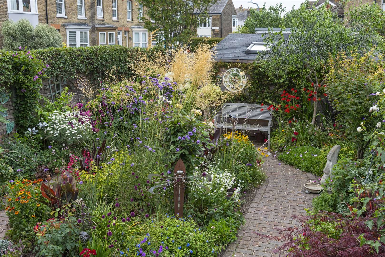 In a 7.5m x 14m back garden, a brick path (in shape of big '6') separates side borders and rear shed from a central bed planted with Stipa gigantea, Verbena bonariensis, roses, dahlias, heleniums, alliums, penstemon, heucheras, hydrangeas and cannas. Pictures Nicola Stocken (48959092)