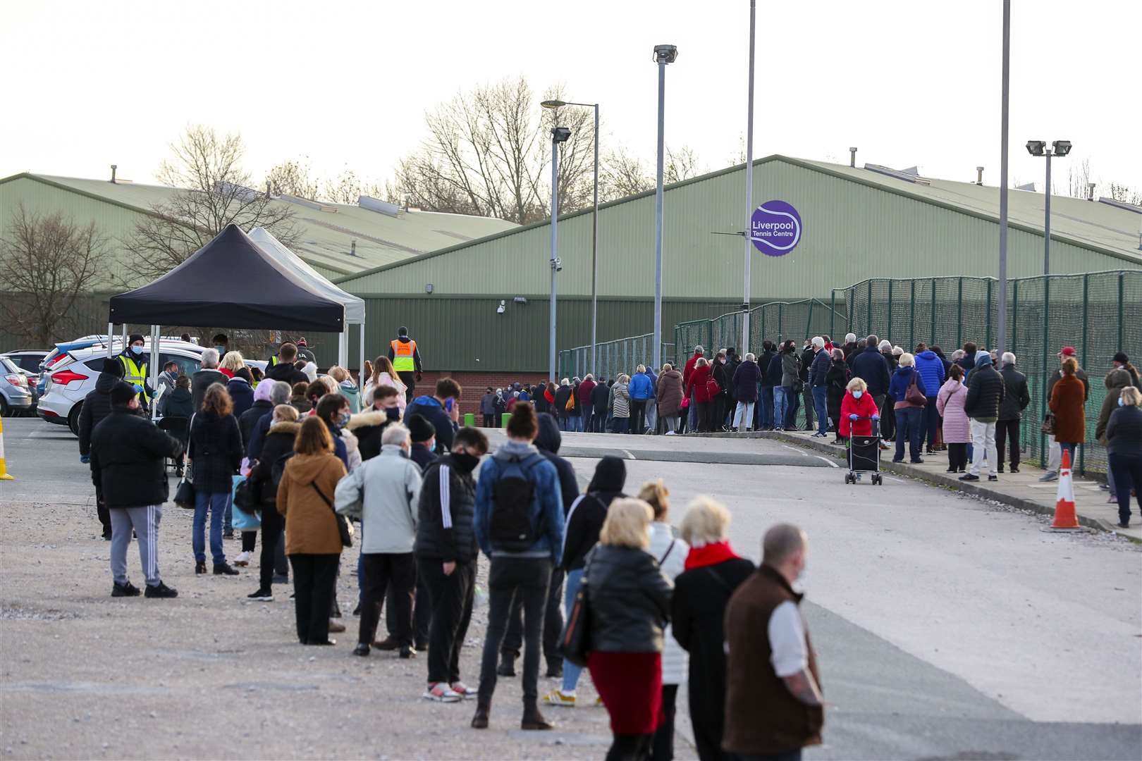 People queue at a Coronavirus testing centre at the Liverpool Tennis Centre (Peter Byrne/PA)