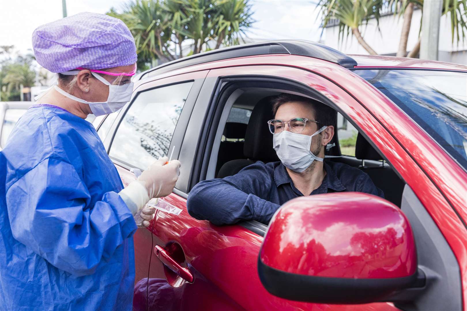 A doctor in a protective suit taking a nasal swab from a person to test for possible coronavirus infection. Picture: iStock