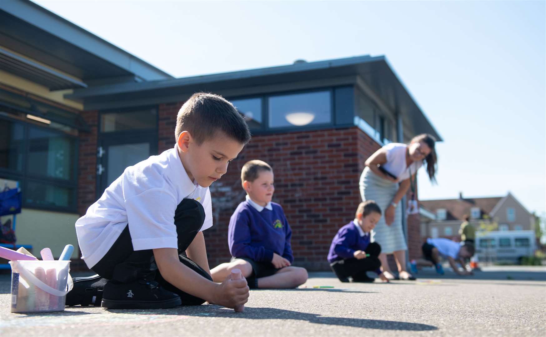 Reception pupil Ollie draws with chalk in the playground at Queen’s Hill Primary School in Costessey, Norfolk (Joe Giddens/PA)