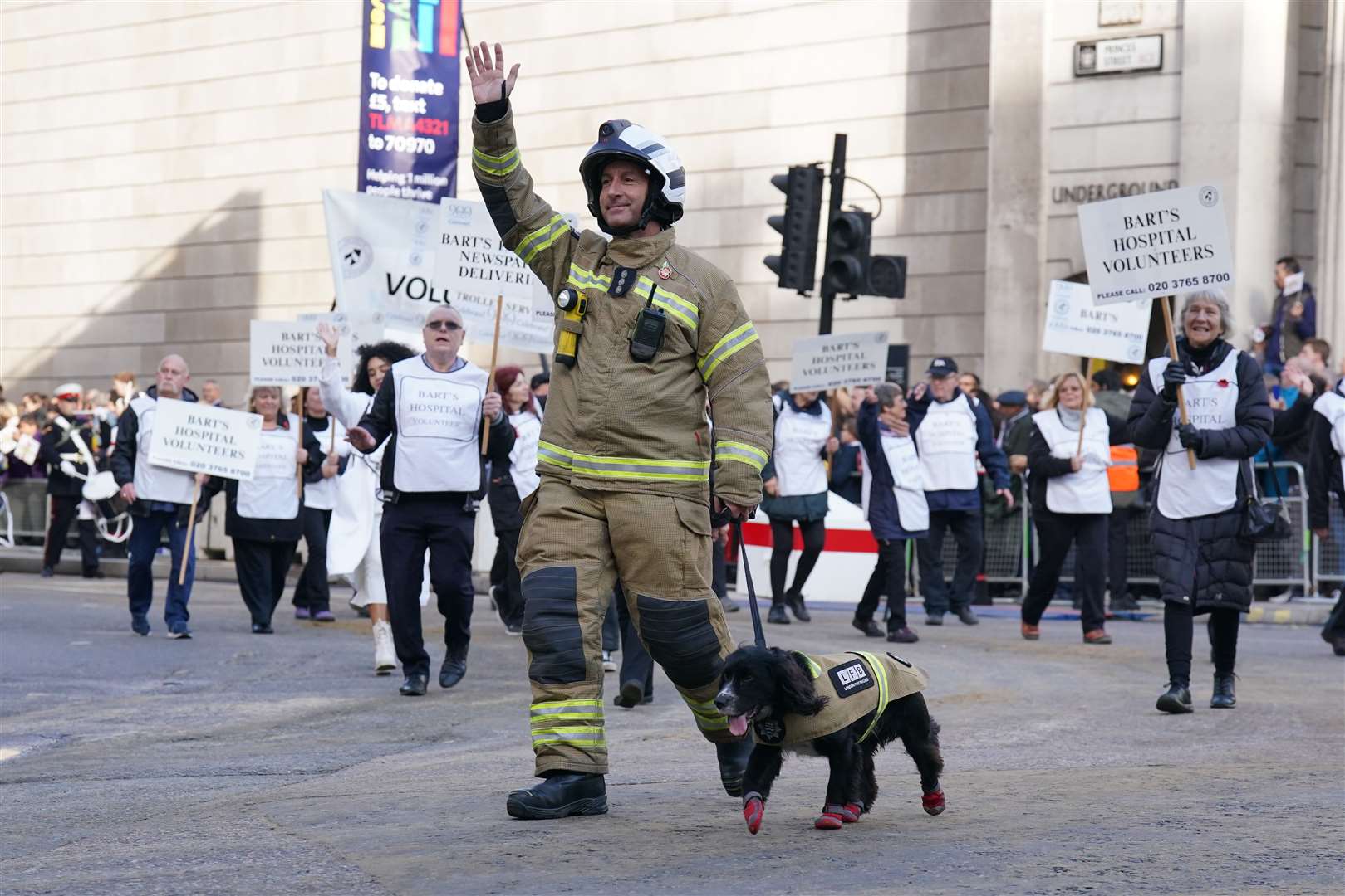 A firefighter with his rescue dog waves to the crowds (Jonathan Brady/PA)