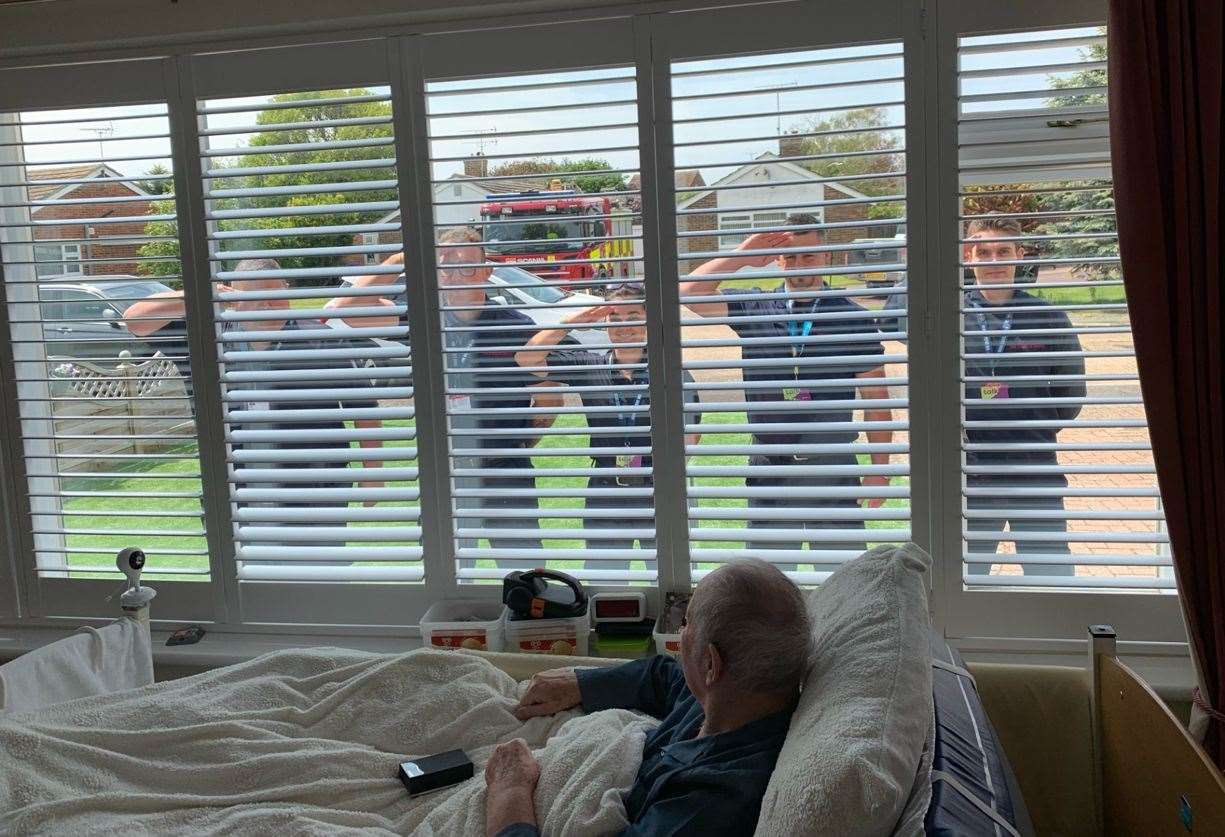 Jim, from Herne Bay, was surprised with an honorary firefighters’ parade and salute at his living room window. Picture: KFRS