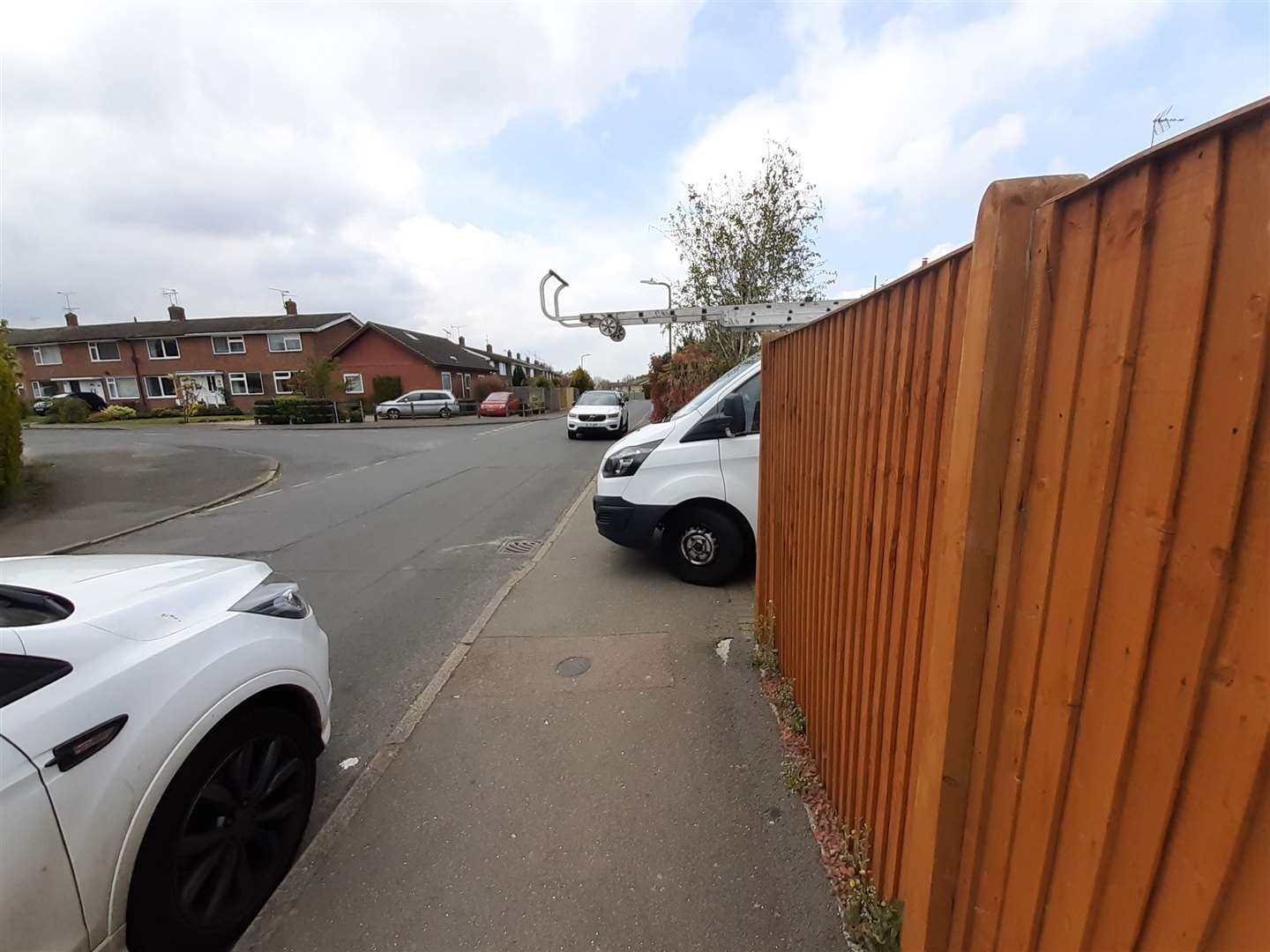 A van parked on a driveway protrudes into the pavement in Offens Drive