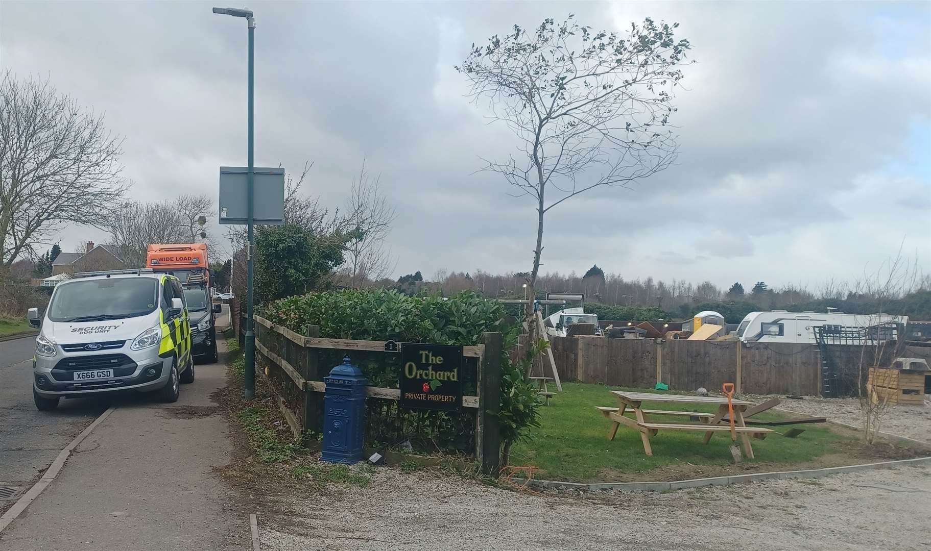 A flat bed lorry waits outside the site