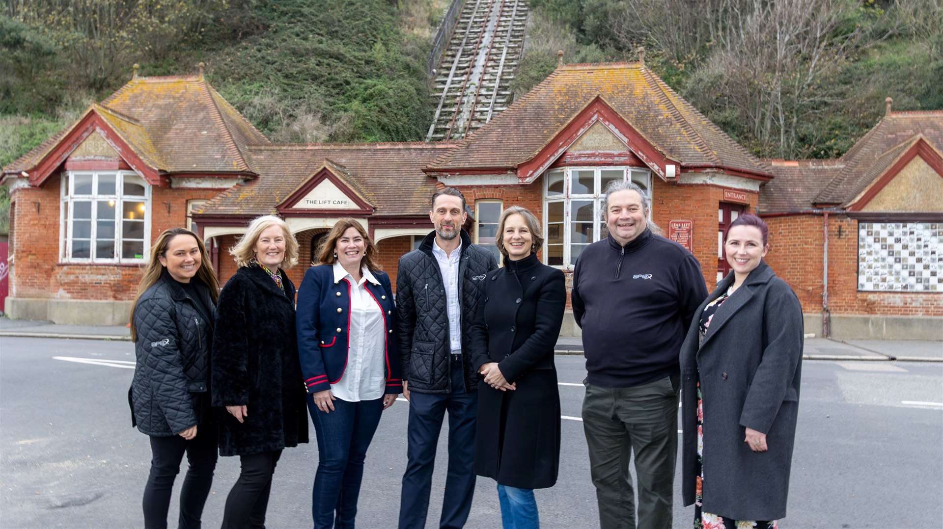 The teams from Apex Contractors and the Leas Lift Company Charity in front of the rundown lift in Folkestone