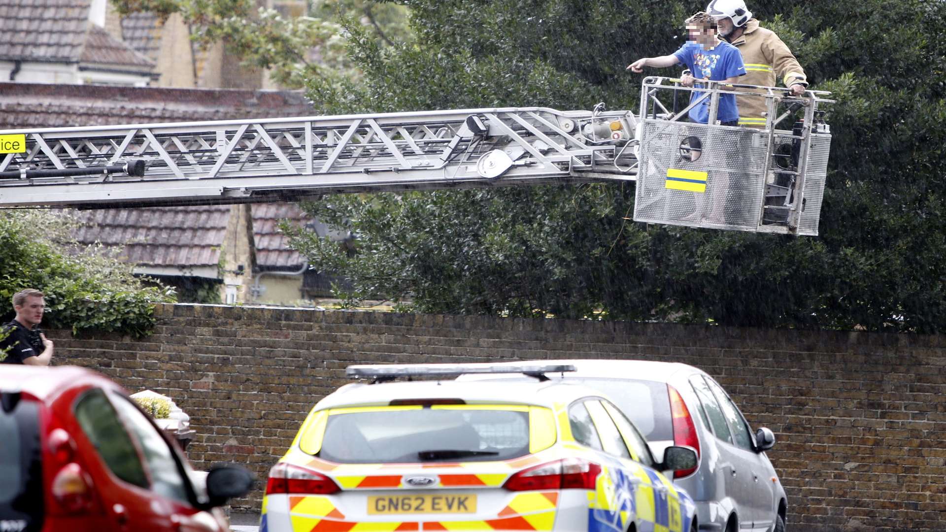 The young man is led down from the roof on a cherry picker. Picture: Matthew Walker