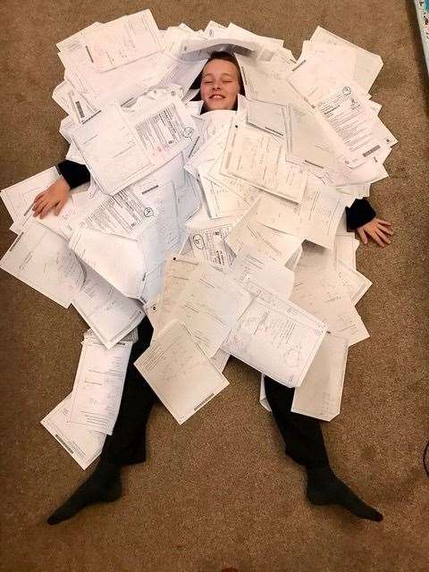 Daniel Mullins, 12, swamped by his GCSE maths papers