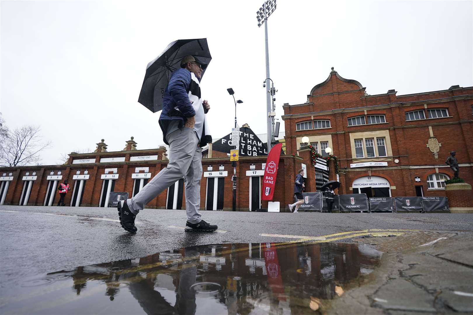 A mans walks past Craven Cottage, London, in wet weather as a new yellow weather warning for rain was issued for southern England (Andrew Matthews/PA)