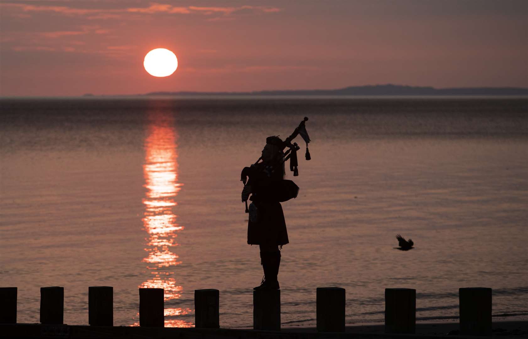 Piper Louise Marshall plays at dawn along Edinburgh’s Portobello Beach as dawn breaks on VE Day (Jane Barlow/PA)