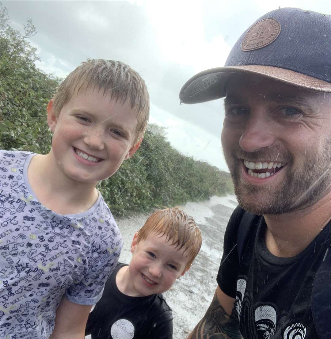 Oliver Tanton Brown and his two sons Sammy, 8 and Jacob, 5 run through the rain after discovering a WW2 bomb