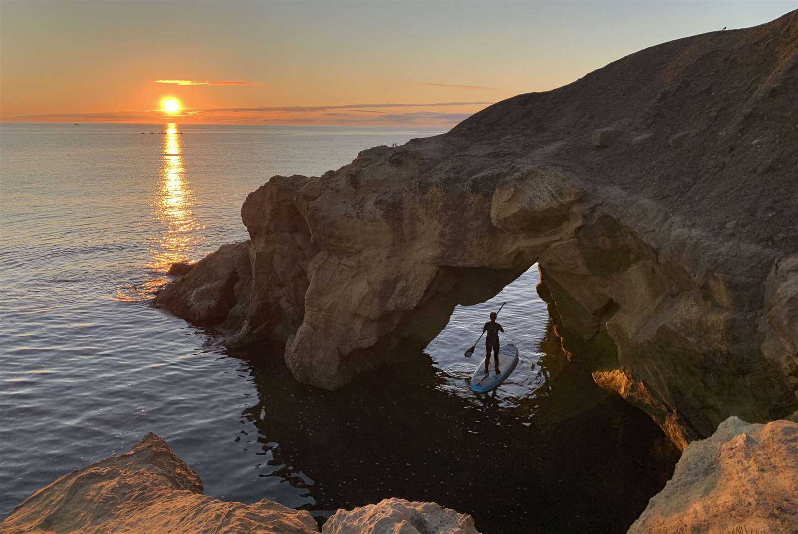 A paddleboarder watches the sun rise at Cullercoats Bay in North Tyneside on August 8 (Owen Humphreys/PA)