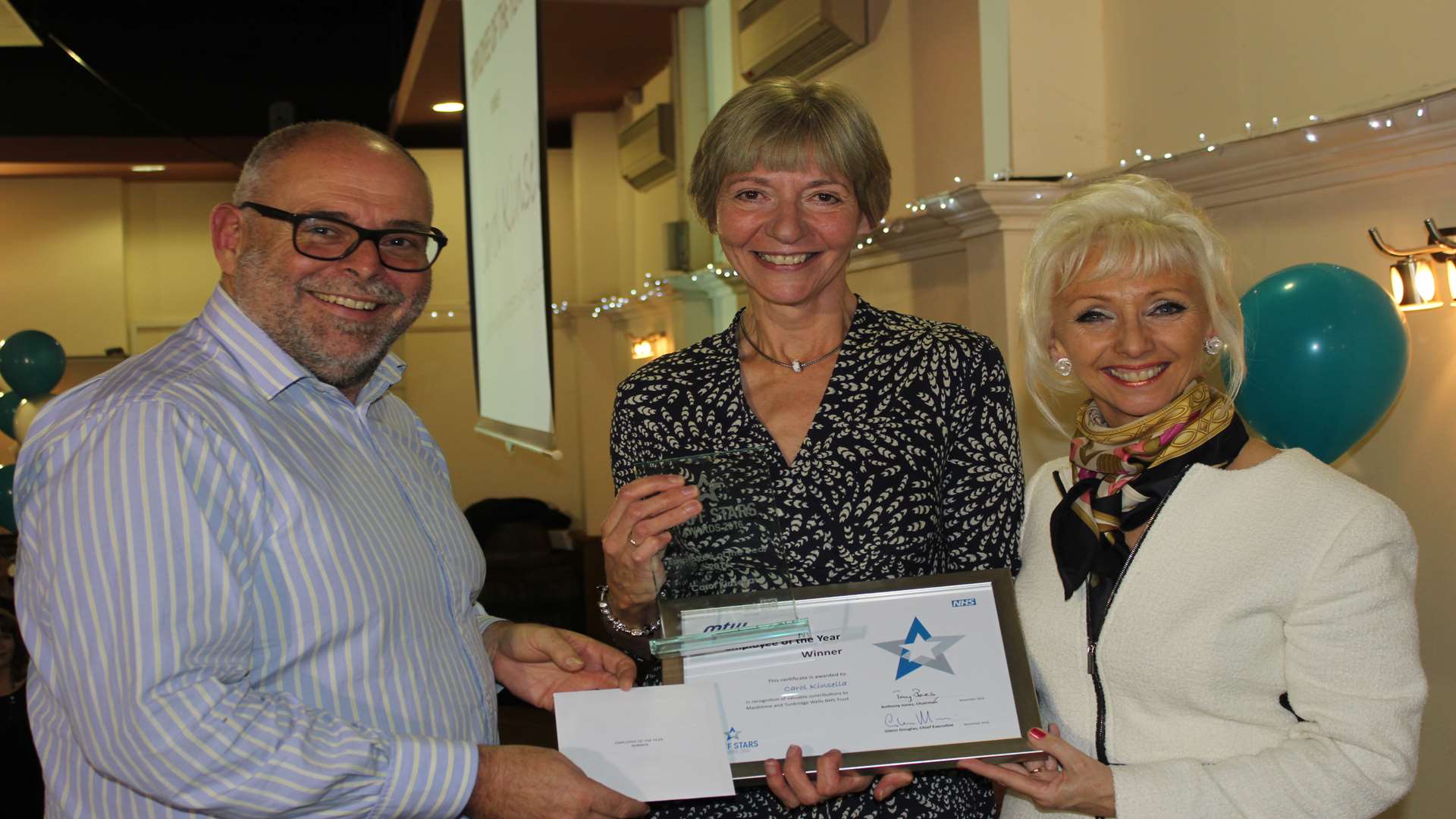 Carol Kinsella, employee of the year, receives her award from Glenn Douglas and Debbie McGee.