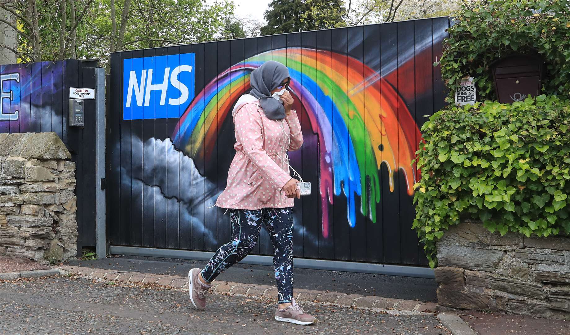 A woman walks past rainbow NHS graffiti in Newcastle (Owen Humphreys/PA)