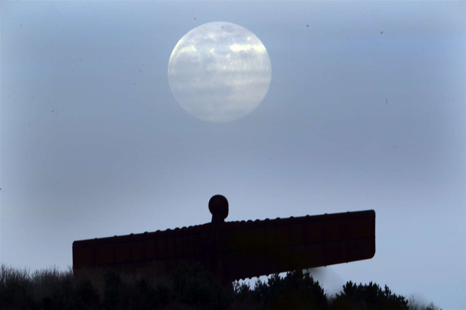 The pink supermoon is seen over the Angel of the North (Owen Humphreys/PA)