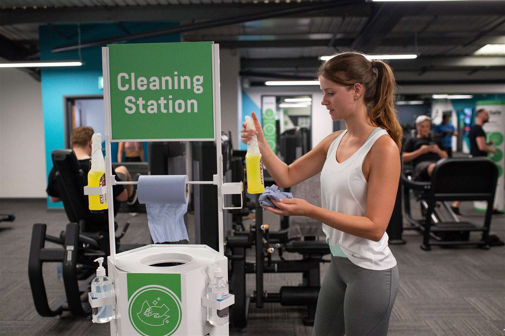 A gym member uses the cleaning station at PureGym in Leamington Spa (Jacob King/PA)