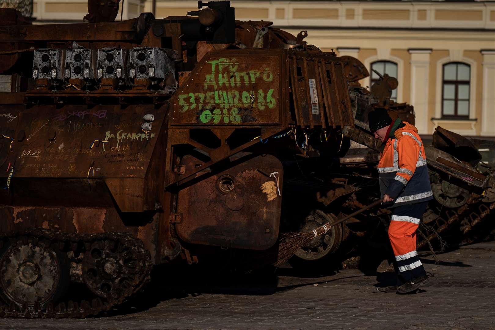 A city worker cleans around the military equipment exhibition in Mykhailivska Square (Aaron Chown/PA)