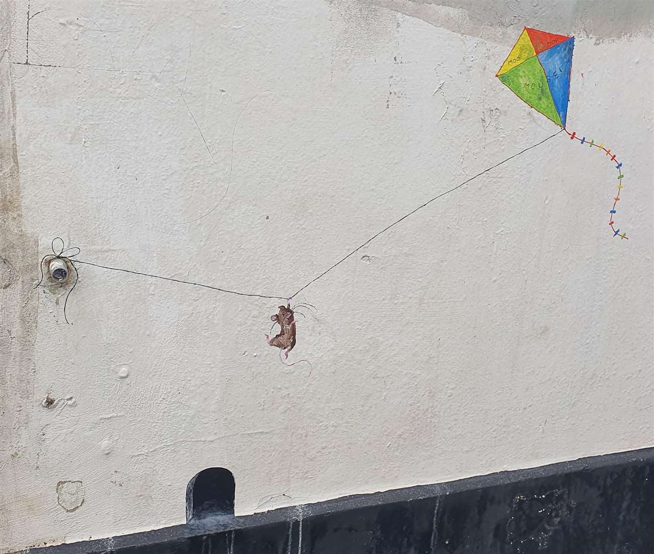 Flying high: Moo Mop Mouse takes to the air with a kite tethered to a water overflow pipe on the seafront on the Isle of Sheppey