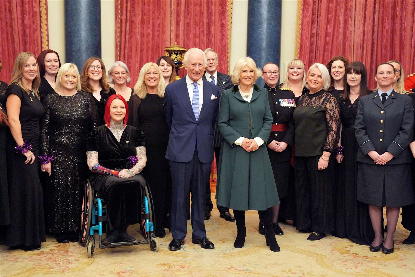 The Military Wives Choir pose for a photo with Charles and Camilla at Buckingham Palace (Yui Mok/PA)