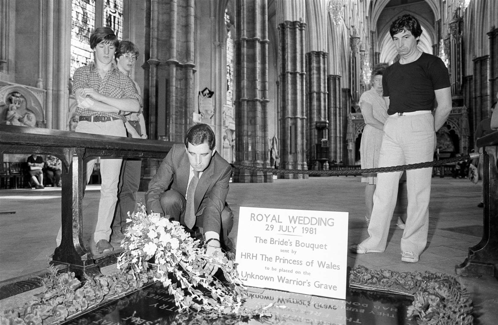 Stuart Holmes, deputy registrar of Westminster Abbey, places the bridal bouquet from Princes Diana following her wedding to Charles in 1981 (PA)